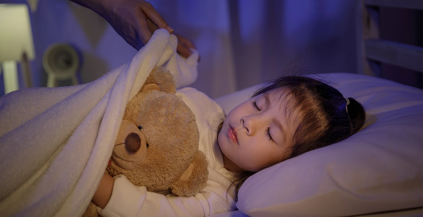 Mom is outting her child to bed after giving her kid melatonin