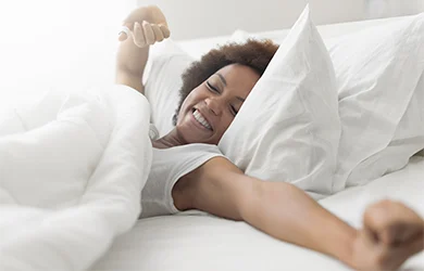 Woman waking up refreshed after taking melatoning the night before 