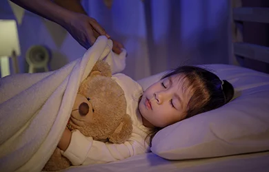 Mom is outting her child to bed after giving her kid melatonin