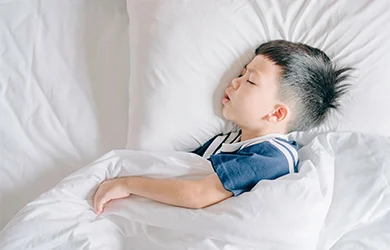 Little boy sleeping in his bed 